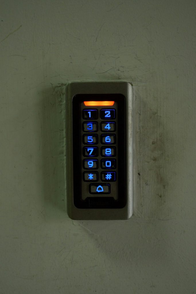 Illuminated access control keypad mounted beside a commercial door