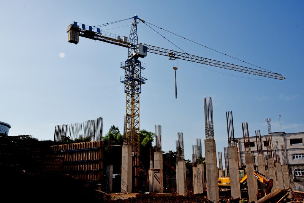 Tower crane above a construction site with concrete columns
