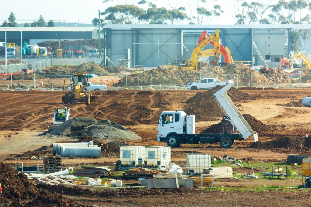 Australian construction site with trucks, machinery and site fencing