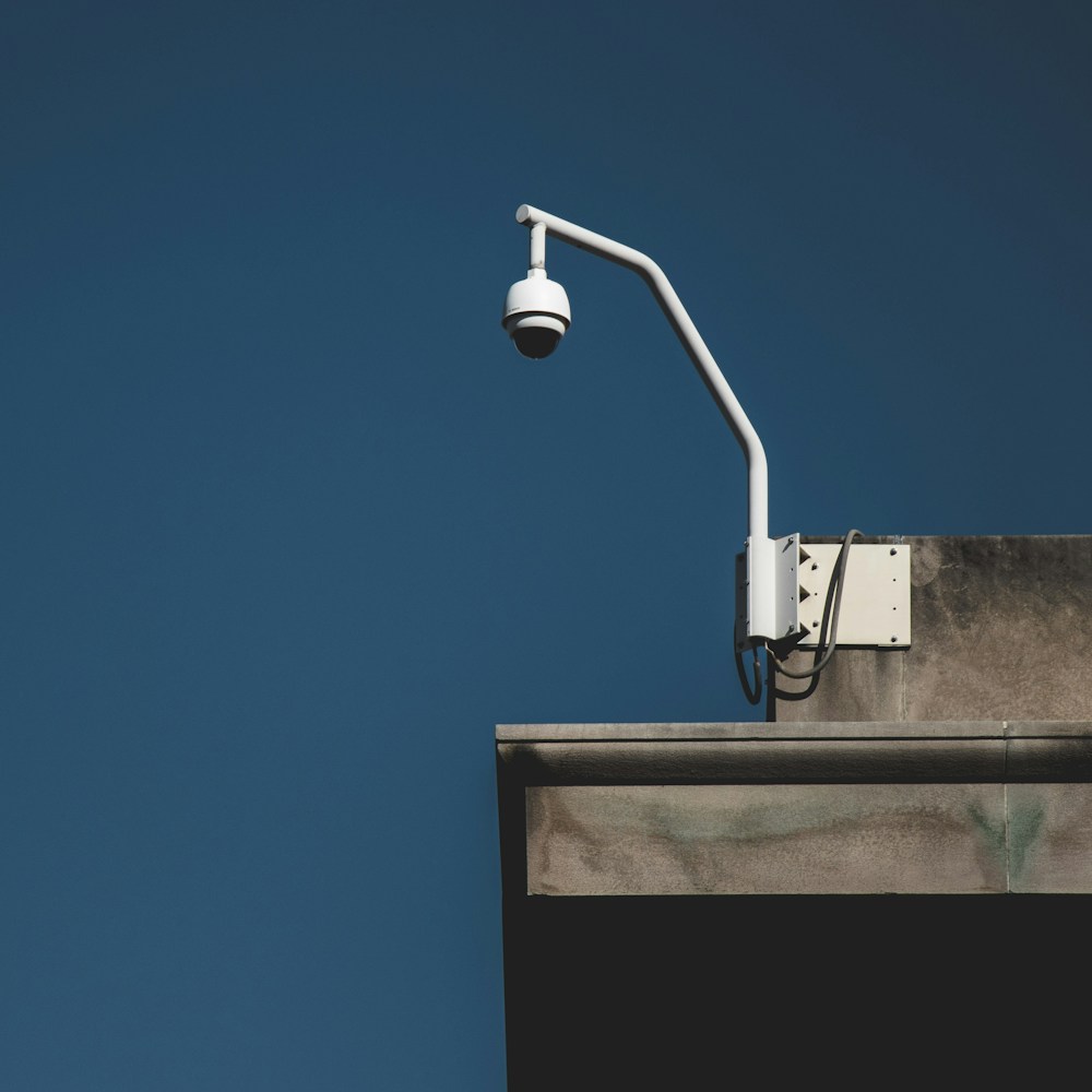 Dome security camera on a bracket against a deep blue wall